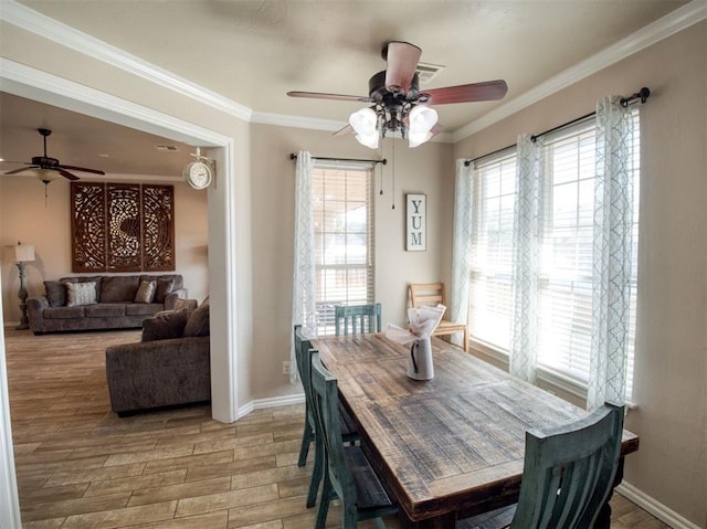 dining room with ornamental molding, light wood-type flooring, ceiling fan, and baseboards