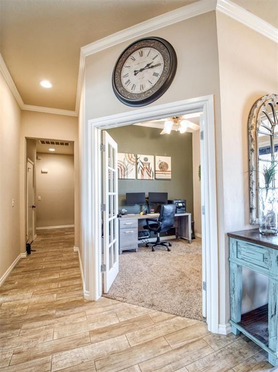 office with baseboards, wood tiled floor, visible vents, and crown molding