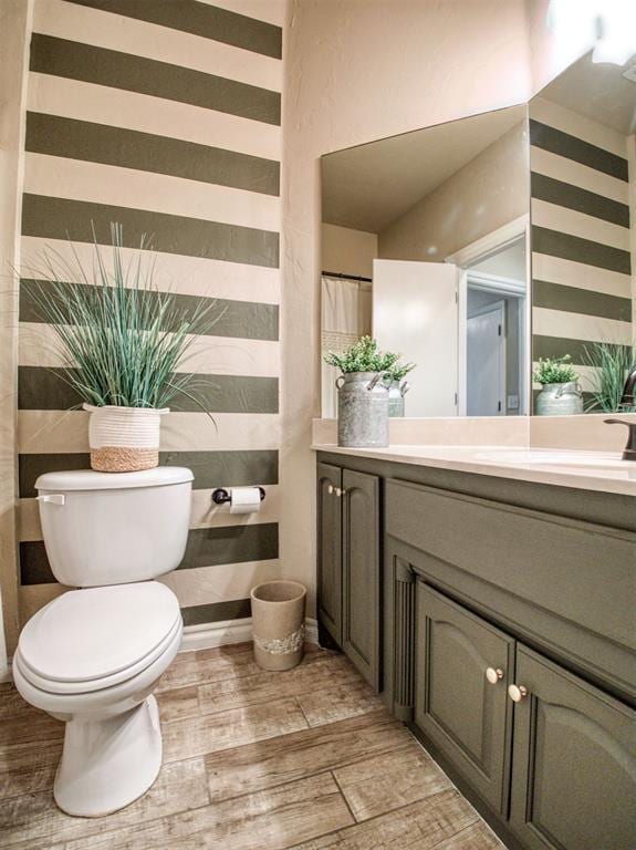 bathroom featuring vanity, hardwood / wood-style floors, and toilet