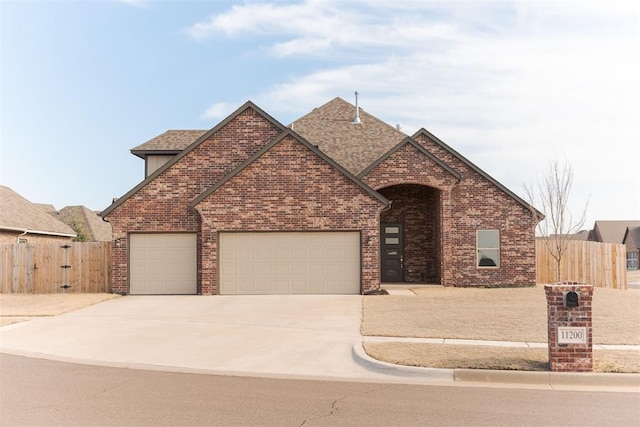 traditional-style home featuring roof with shingles, brick siding, an attached garage, fence, and driveway