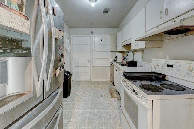 kitchen with appliances with stainless steel finishes, sink, light tile patterned floors, and white cabinets