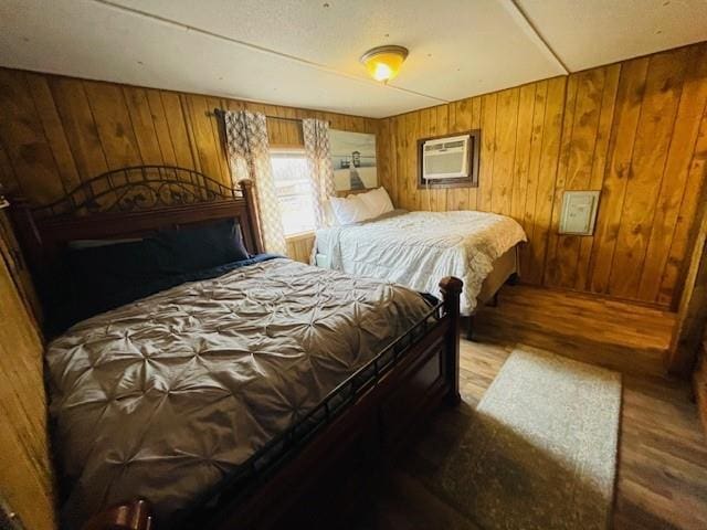 bedroom featuring a wall mounted AC and wood walls