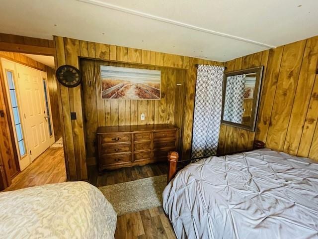 bedroom featuring wooden walls and hardwood / wood-style floors