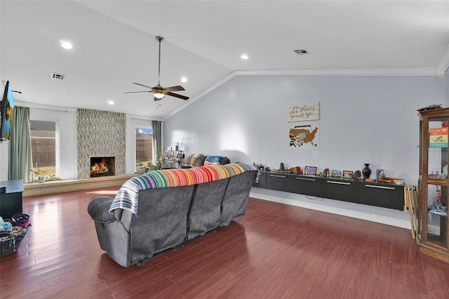 living room featuring crown molding, a fireplace, dark hardwood / wood-style flooring, and vaulted ceiling