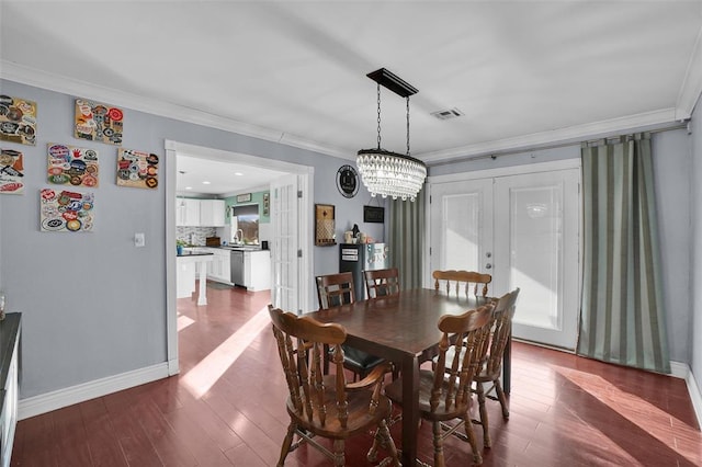 dining area with ornamental molding, plenty of natural light, an inviting chandelier, and dark hardwood / wood-style flooring