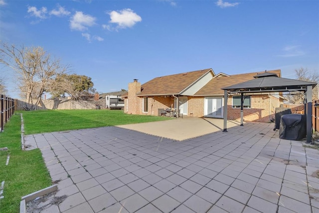 back of house featuring a gazebo, a lawn, and a patio