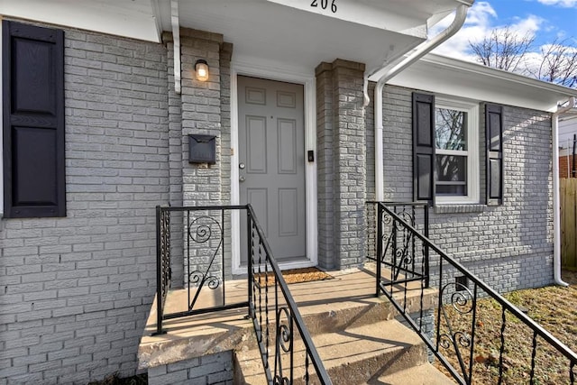 doorway to property featuring brick siding