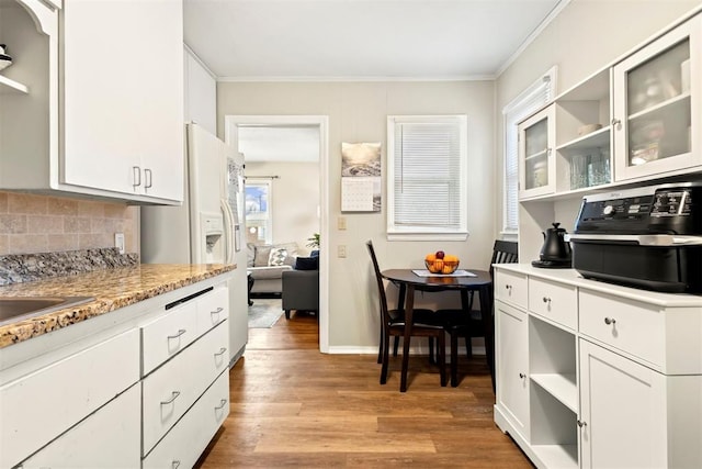 kitchen with white cabinetry, tasteful backsplash, ornamental molding, and light hardwood / wood-style flooring