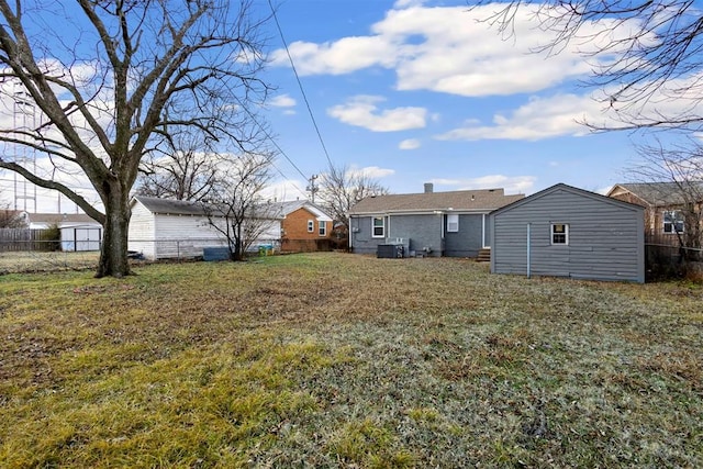 rear view of house featuring an outdoor structure and a lawn