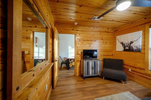 sitting room featuring wooden ceiling, light hardwood / wood-style floors, and wood walls