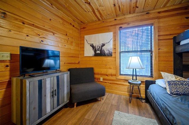 living area with wood-type flooring, wooden ceiling, and wooden walls