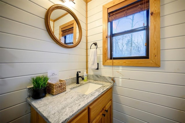 bathroom featuring vanity and wood walls