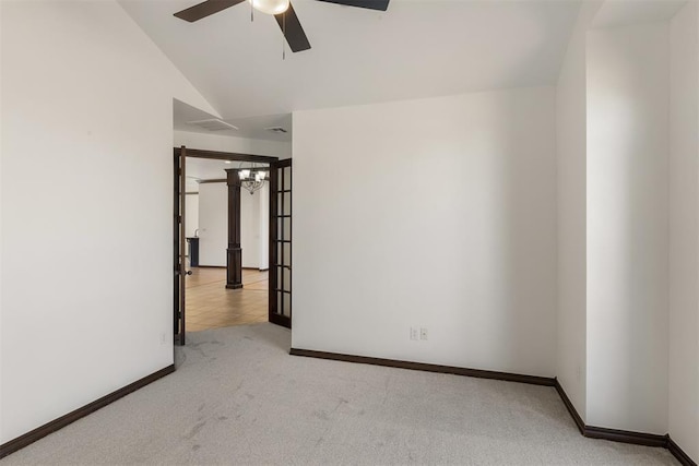 unfurnished room with ceiling fan, lofted ceiling, and light carpet