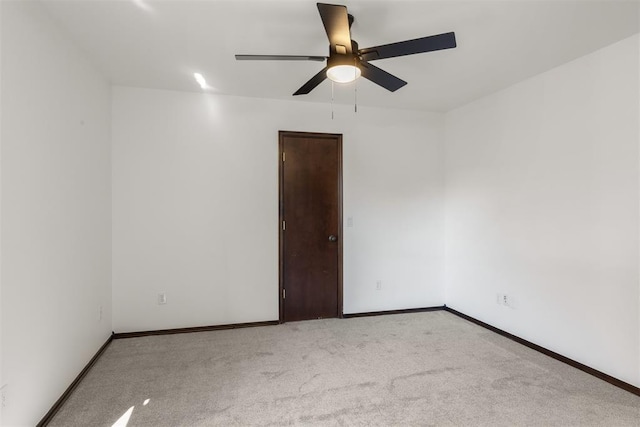 carpeted spare room featuring ceiling fan