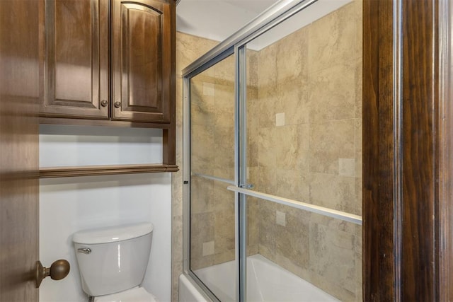 bathroom featuring enclosed tub / shower combo and toilet