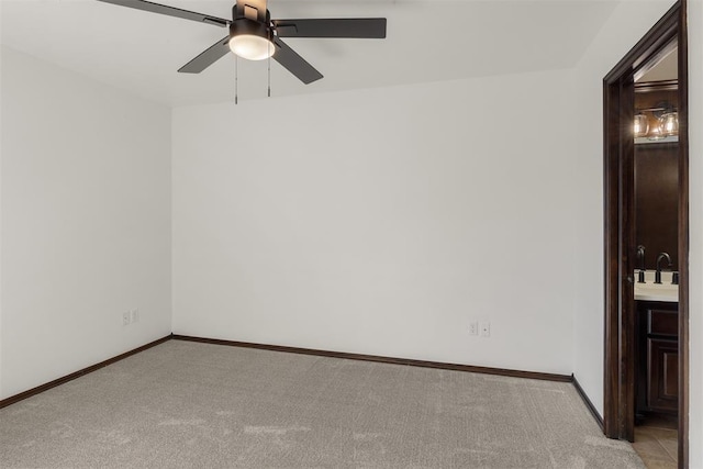spare room featuring sink, light colored carpet, and ceiling fan
