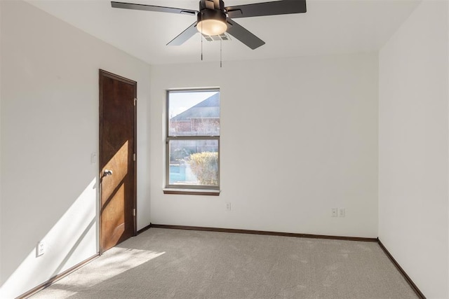 spare room featuring light colored carpet and ceiling fan