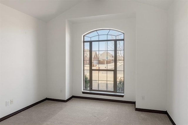 empty room with lofted ceiling and light carpet