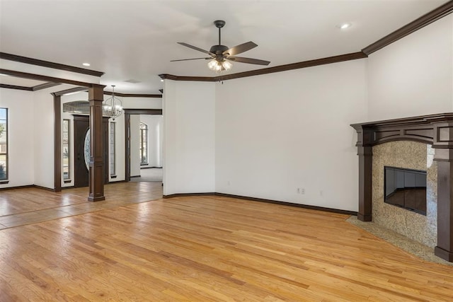 unfurnished living room with crown molding, plenty of natural light, a fireplace, and light wood-type flooring
