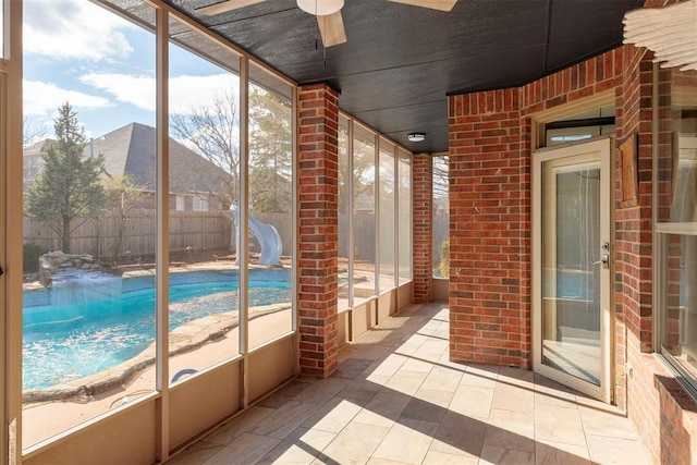 unfurnished sunroom with ceiling fan