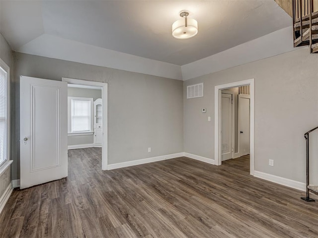 unfurnished room with dark wood-type flooring and vaulted ceiling