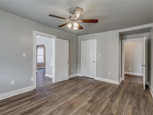 empty room with ceiling fan and dark hardwood / wood-style flooring