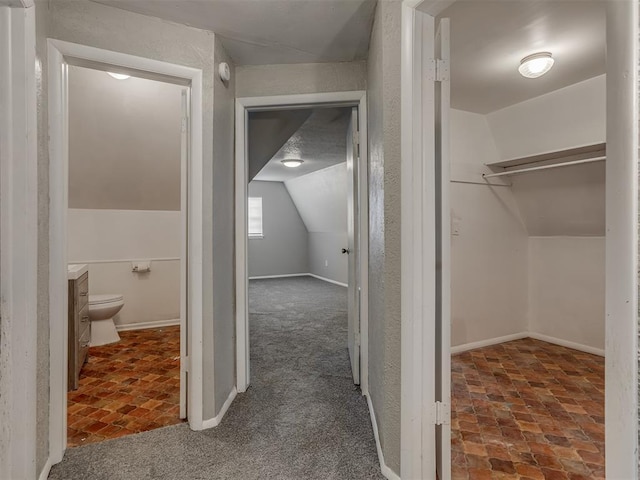 bathroom featuring lofted ceiling, vanity, and toilet