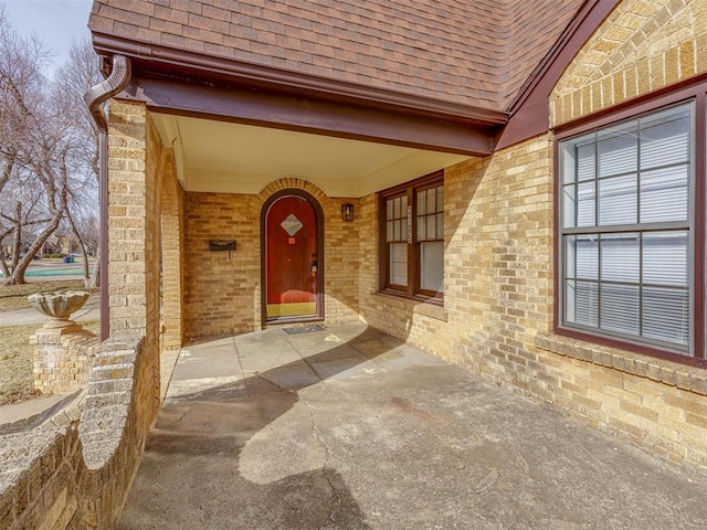 3105 NW 22nd St, Oklahoma City, OK 73107 - doorway to property featuring roof with shingles and brick siding