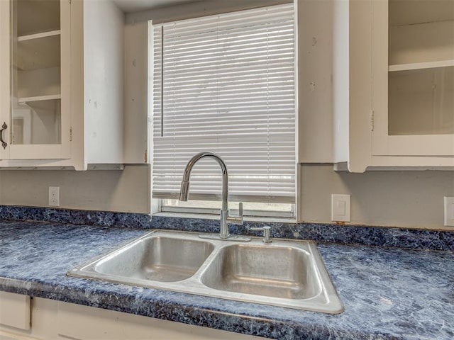 3105 NW 22nd St, Oklahoma City, OK 73107 - kitchen view of a sink, dark countertops, glass insert cabinets, and white cabinetry