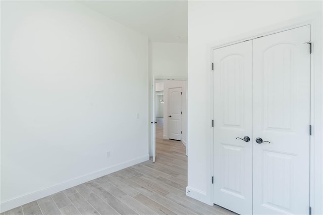 unfurnished bedroom with light hardwood / wood-style floors and a closet