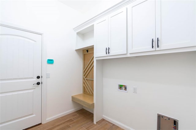 laundry area with hookup for a washing machine, light hardwood / wood-style flooring, and cabinets