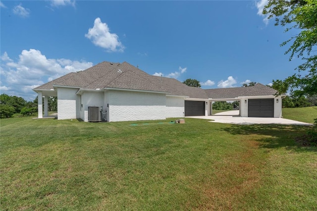 view of front of house with a garage, central AC, and a front yard