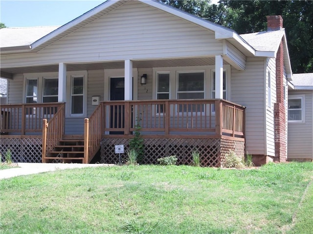 view of front of home featuring covered porch and a front lawn