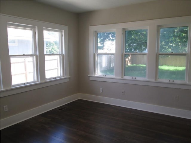 empty room with dark hardwood / wood-style flooring