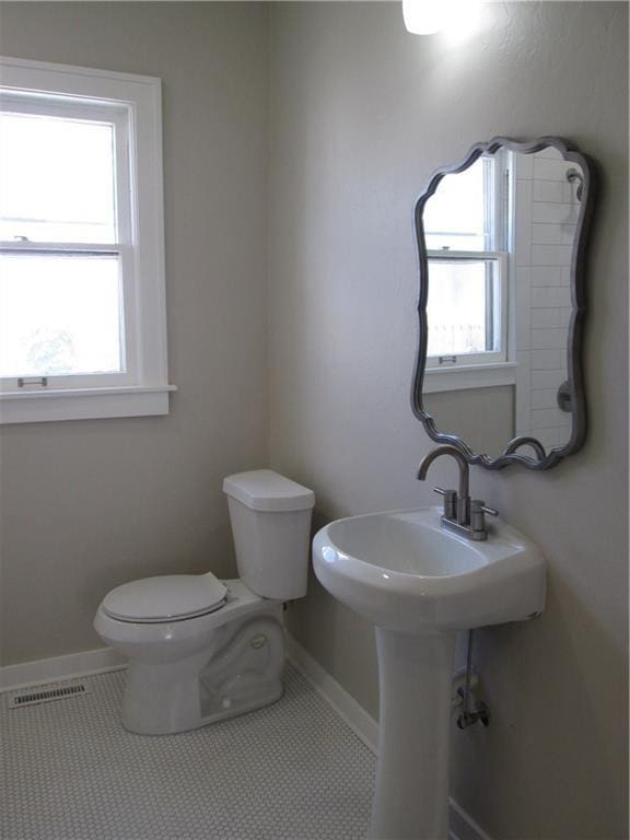 bathroom featuring tile patterned floors, toilet, and a healthy amount of sunlight