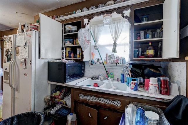 kitchen with white refrigerator with ice dispenser and sink