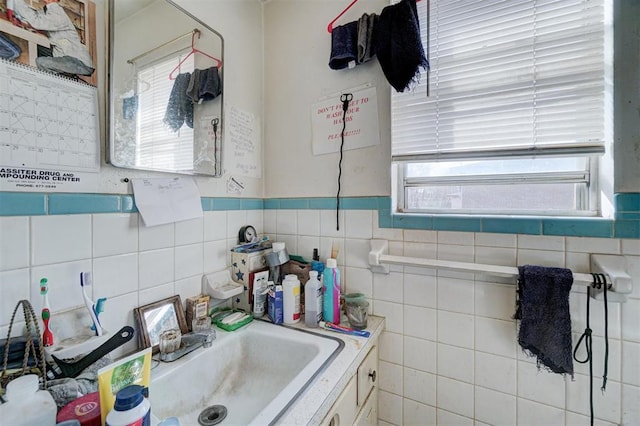 bathroom with vanity and tile walls