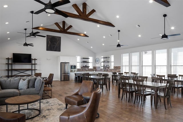 living area featuring a ceiling fan, beam ceiling, visible vents, and wood finished floors