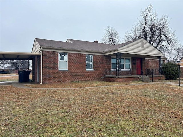 view of front of home featuring a front lawn, a carport, and covered porch