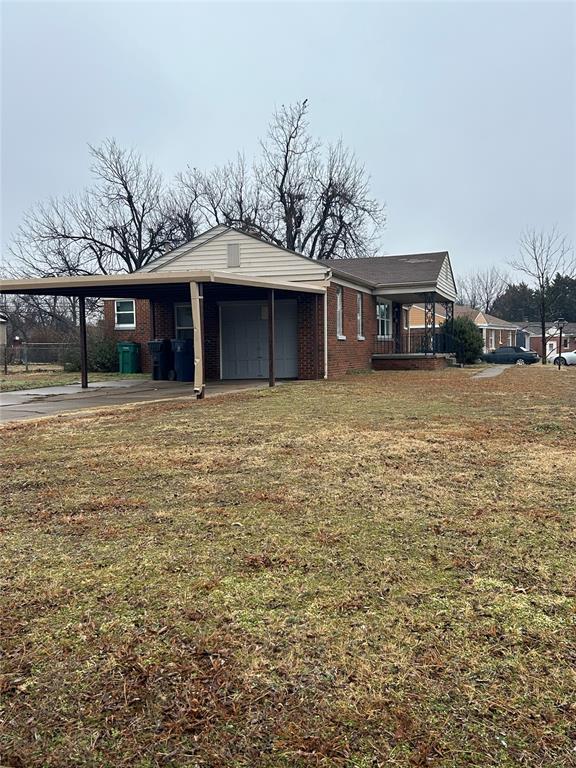 ranch-style house with a carport, a garage, a porch, and a front lawn