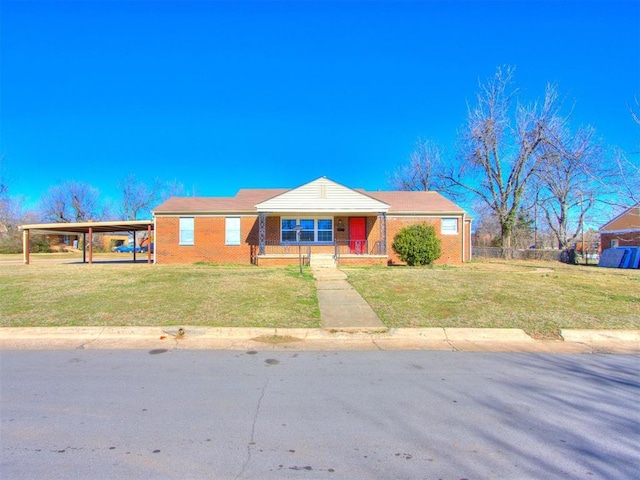 view of front of property with a carport, a front yard, covered porch, and brick siding