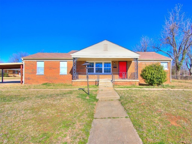 view of front of house with covered porch, a carport, a front lawn, and brick siding