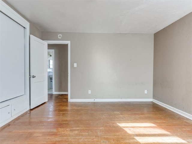 unfurnished room featuring light wood-type flooring and baseboards