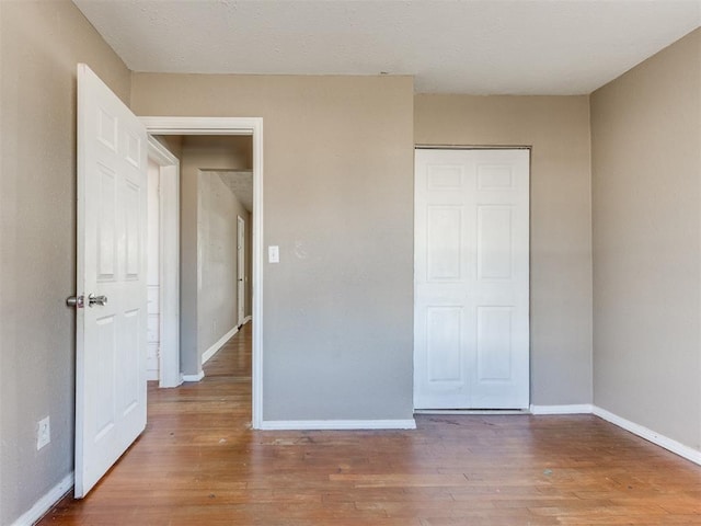 unfurnished bedroom featuring baseboards and wood finished floors