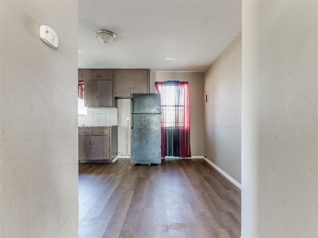 empty room featuring dark wood-style floors and baseboards