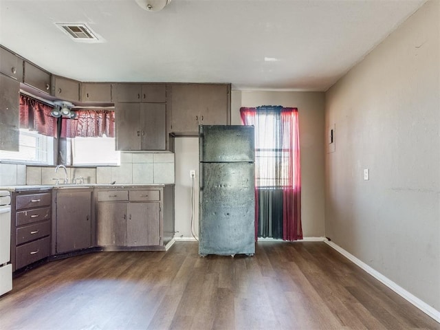 kitchen featuring dark wood-style floors, visible vents, a wealth of natural light, and freestanding refrigerator