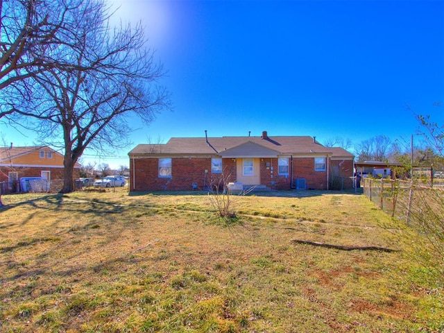 back of property featuring a yard, brick siding, and fence