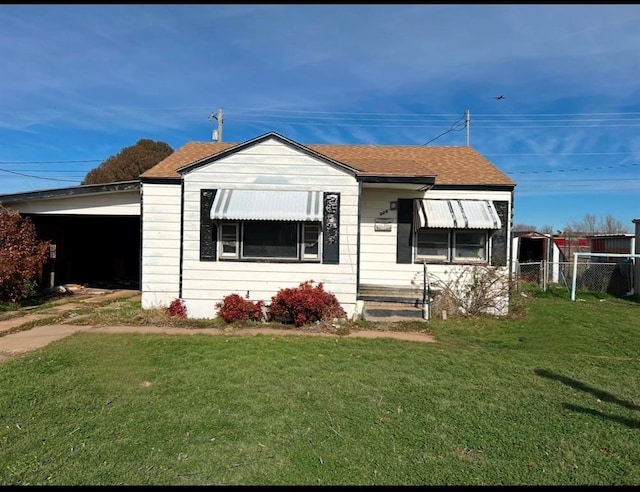 view of front facade featuring a front lawn and a carport