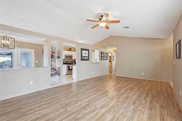 unfurnished living room with lofted ceiling, built in shelves, ceiling fan with notable chandelier, and light hardwood / wood-style flooring