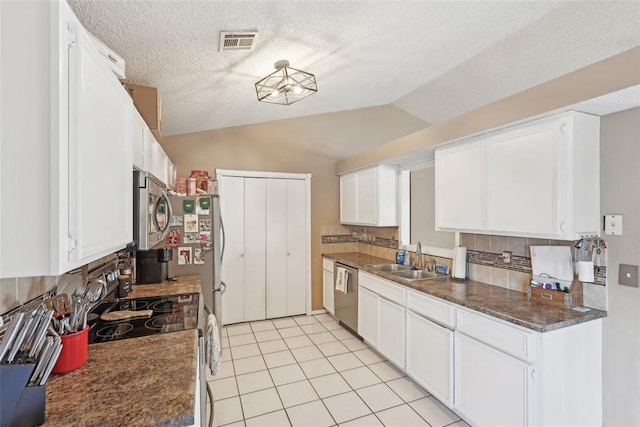 kitchen with lofted ceiling, sink, white cabinets, and appliances with stainless steel finishes